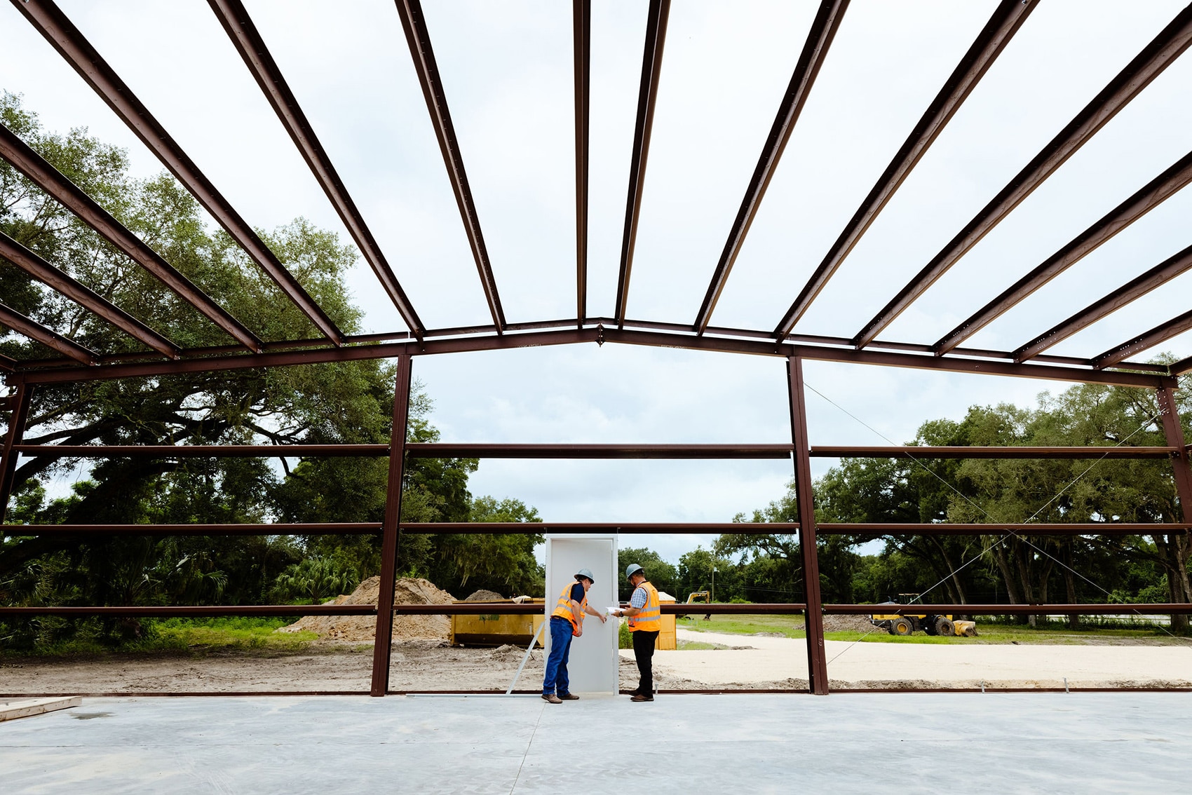 frame of a building with two construction workers